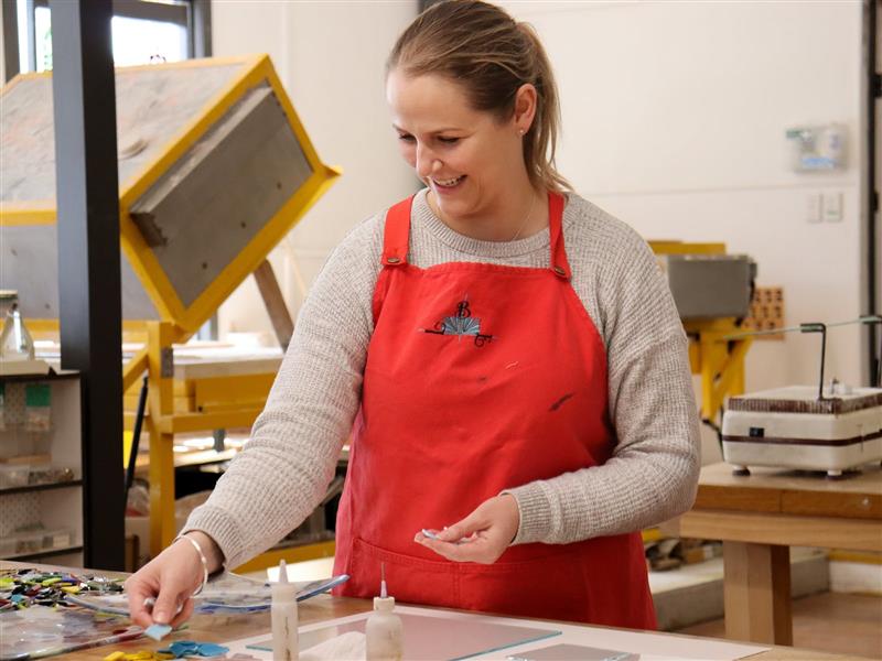 A student choosing glass to make their fused glass platter in their workshop in Macedon Ranges
