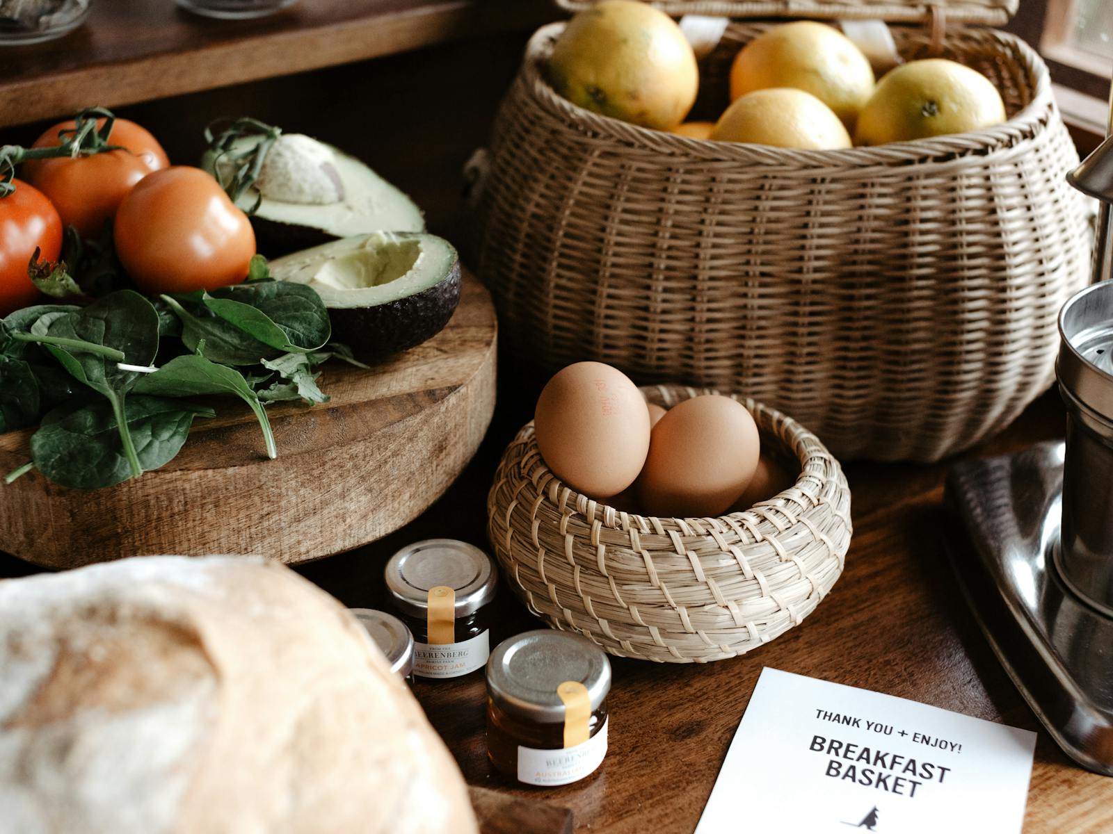 A breakfast selection of fresh seasonal produce, bread, muesli and juice spread out on the bench.