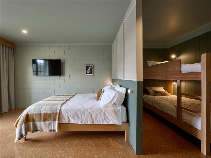 room with queen bed and bunks custom made from sustainably sourced hardwood